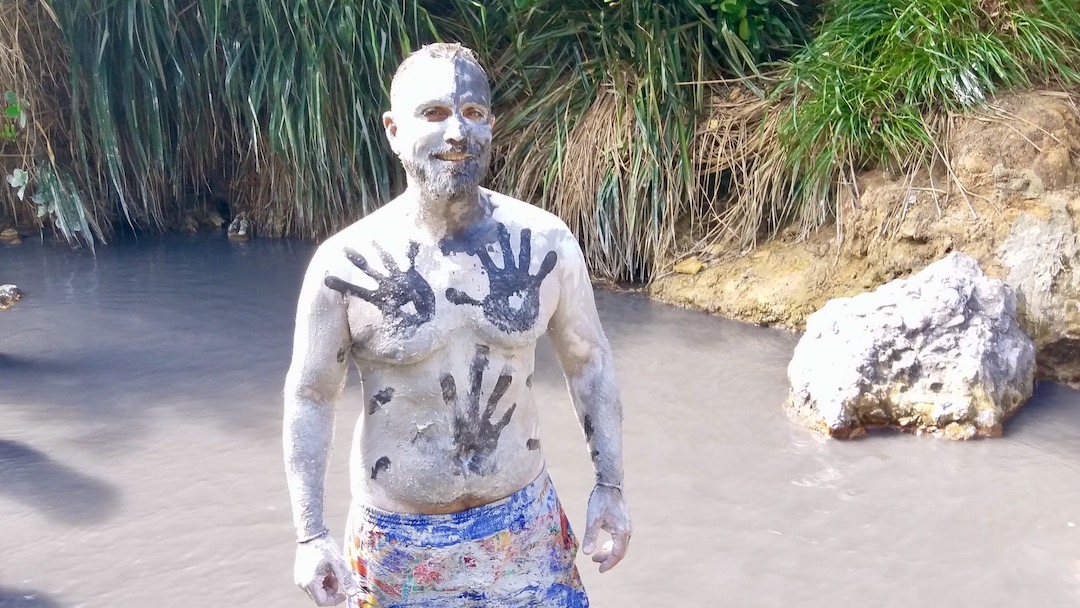 John Zeus at the volcanic mud baths in Saint Lucia - Wellness Travel is a new emerging post-pandemic travel trend