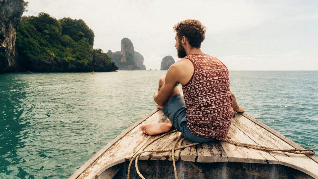 Travel Explorations - Man sitting on a boat